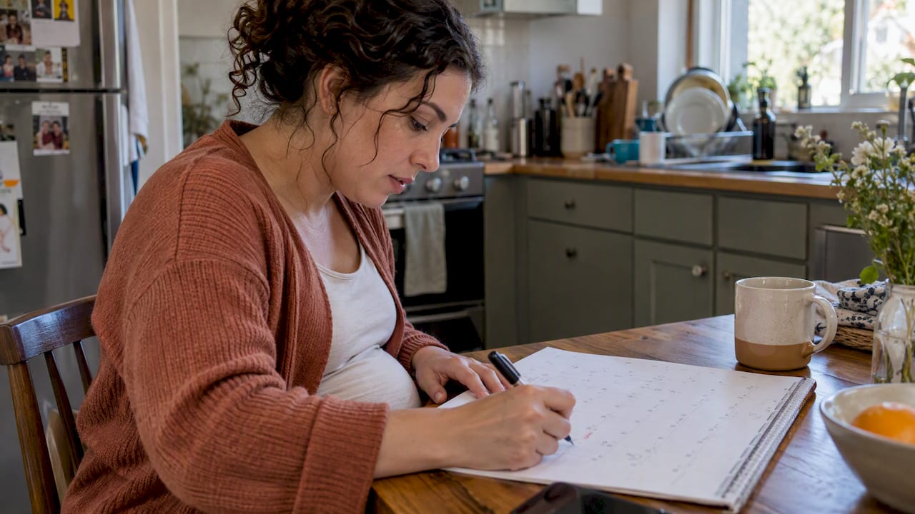 Pregnant woman marking dates on a calendar
